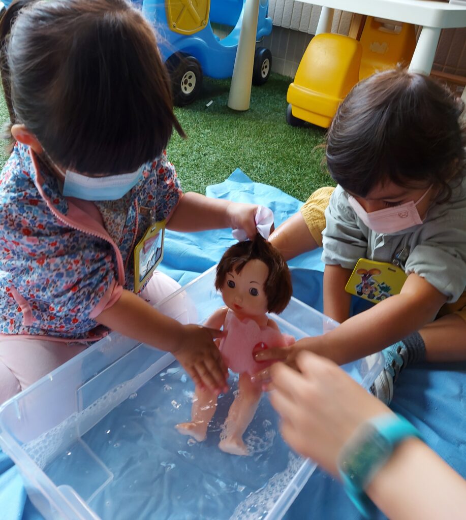 Girls giving doll a bath